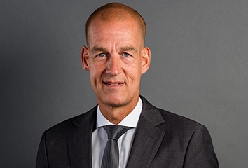 Carsten Cramer – Managing Director – in a dark suit with a dark tie looks straight at the camera (photo)