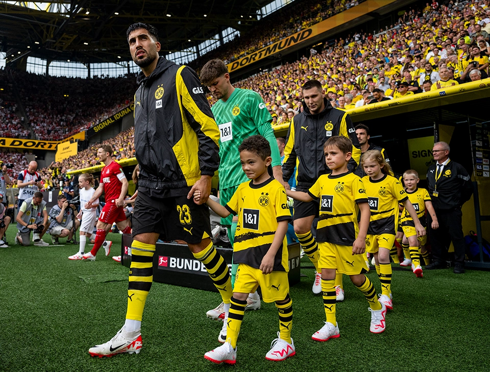Can steps onto field with child mascot (photo)