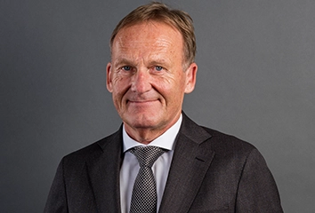 Hans-Joachim Watzke – Chief Executive Officer – in a dark suit with a dark tie looks straight at the camera (photo)