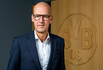 Carsten Cramer – Managing Director – in a dark suit with a dark tie looks straight at the camera (photo)