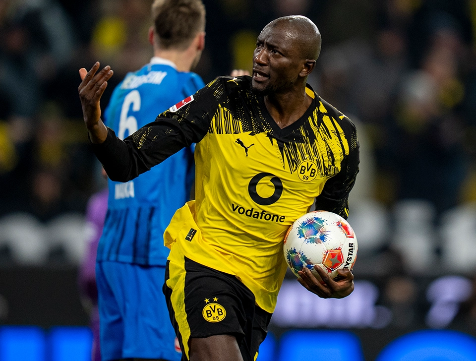 Guirassy running towards the halfway line with the ball in his hands after a goal (photo)