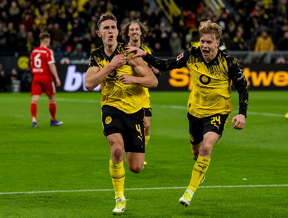 Schlotterbeck pointing to his upper arm while celebrating a goal, Svensson celebrating with him (photo)