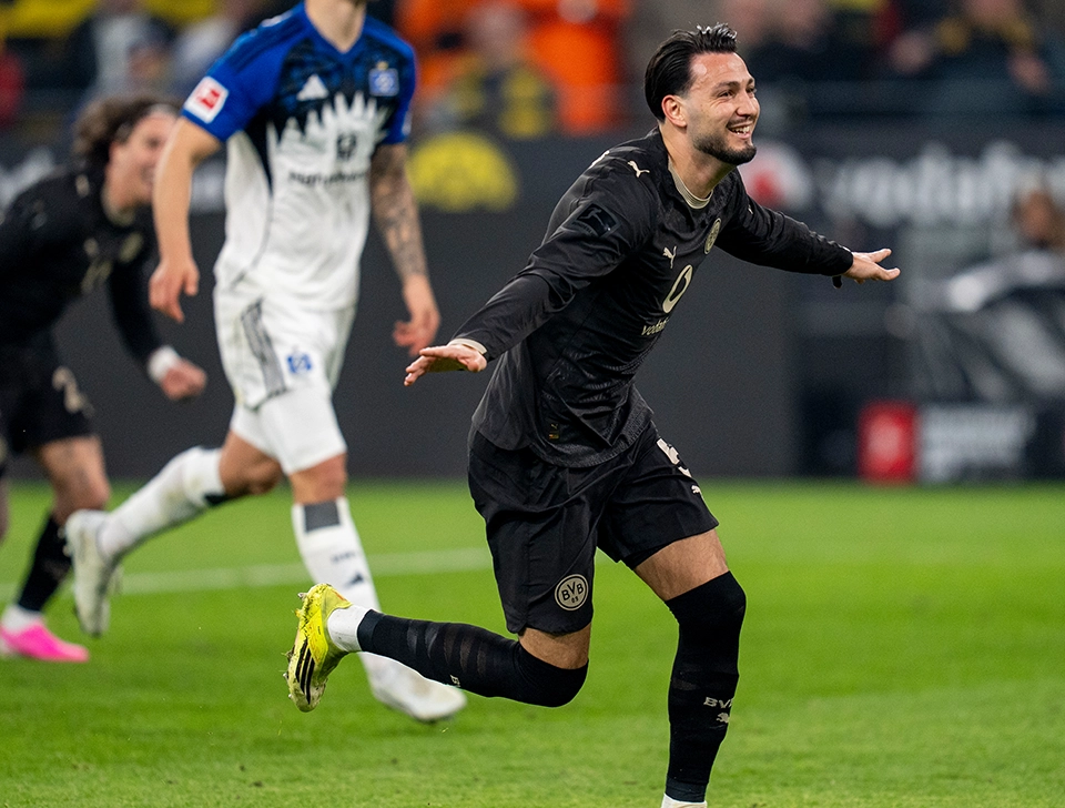 Bensebaini running away in celebration, an HSV player in the background (photo)