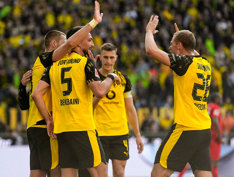 Several BVB players, gathered around Bensebaini and Ryerson, celebrating and high-fiving (photo)