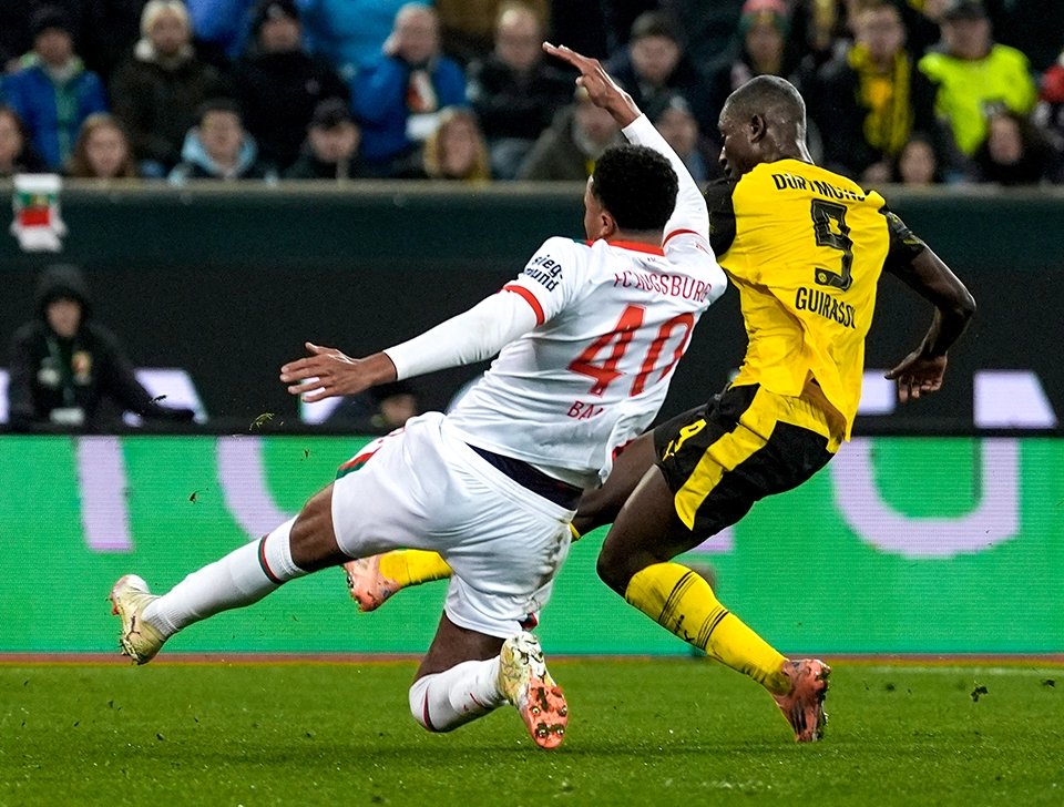 Guirassy shooting at goal under pressure from an Augsburg player (photo)